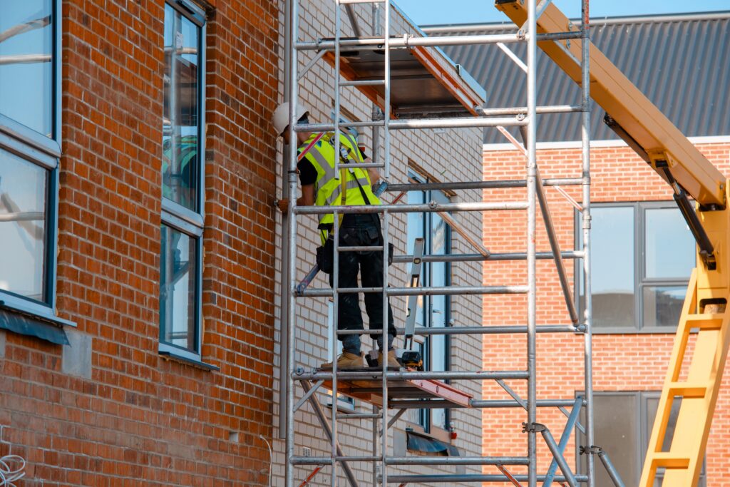 Image d'un homme construisant des échafaudages dans un casque blanc