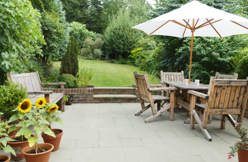 Picture of a garden with patio and lawn and wooden garden furniture