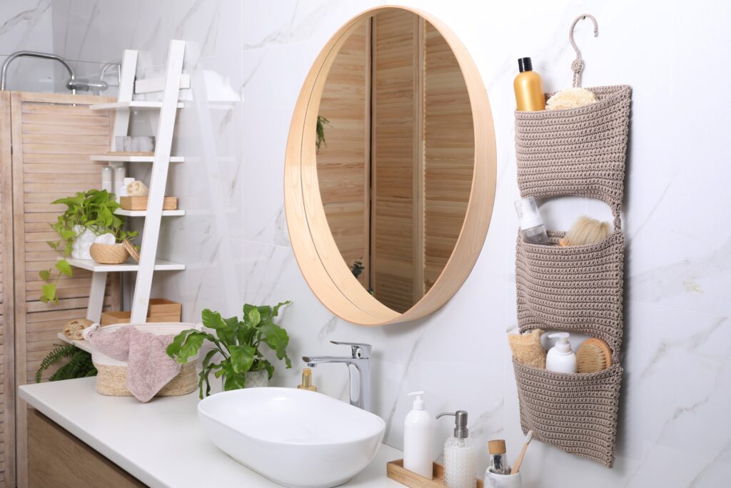 Picture of a bathroom with round mirror and hanging bathroom storage