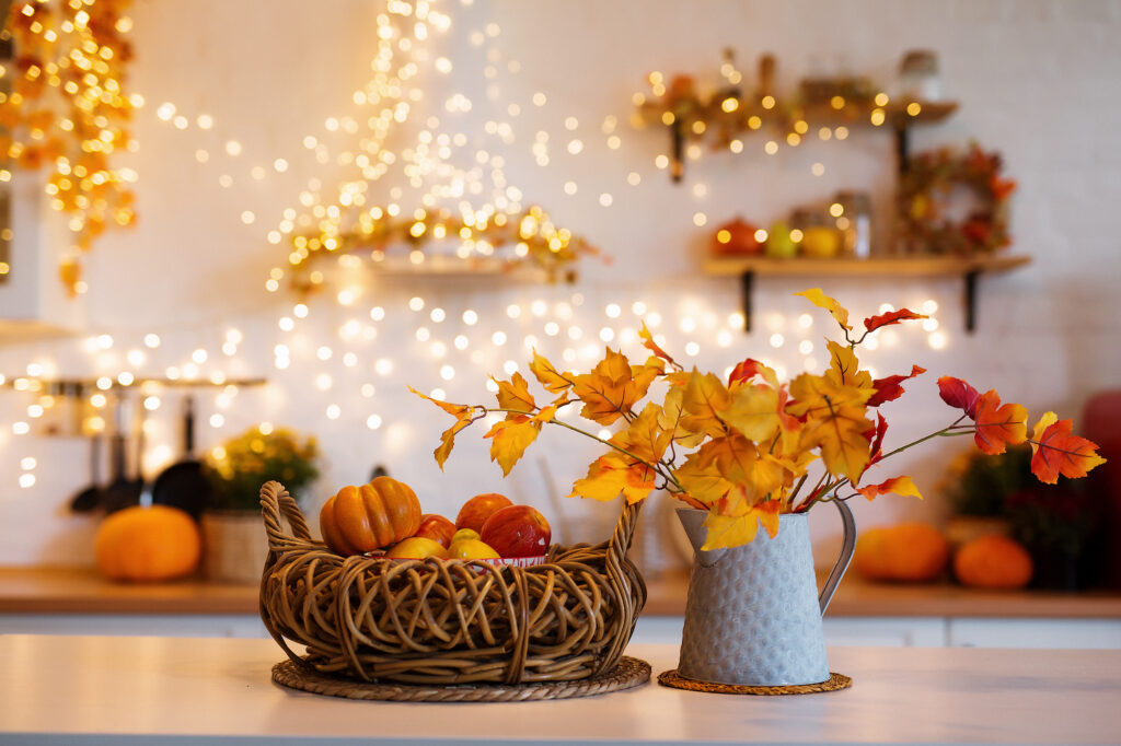 Picture of a a countertop with autumnal decorations like pumpkins and autumn leaves