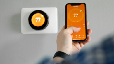 Picture of a man adjusting a smart thermostat using his phone