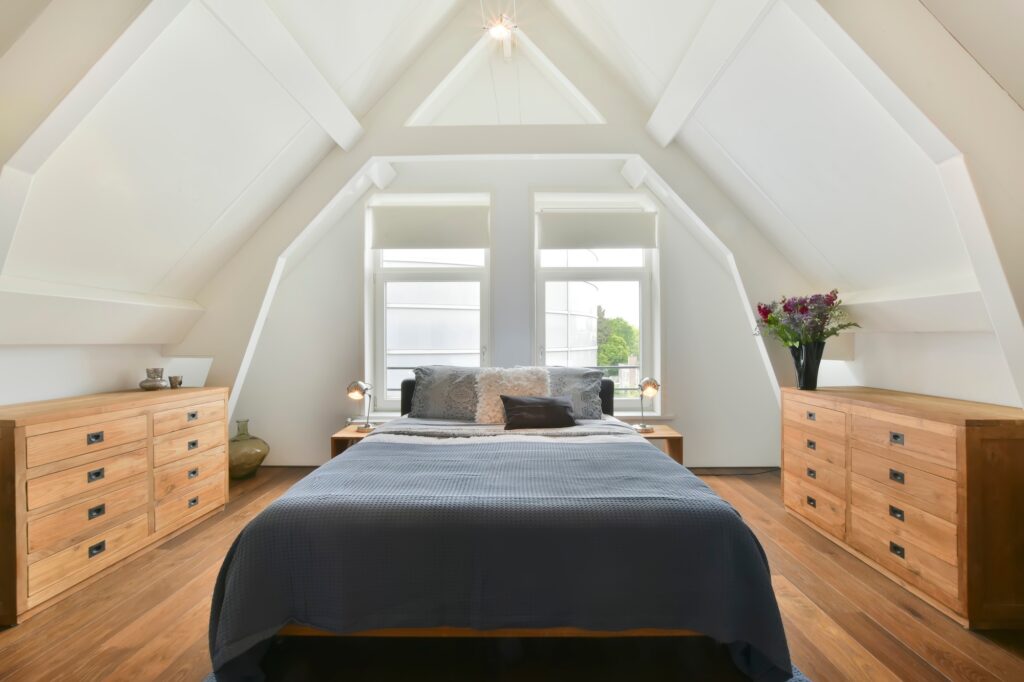 Picture of an attic bedroom with wooden drawers