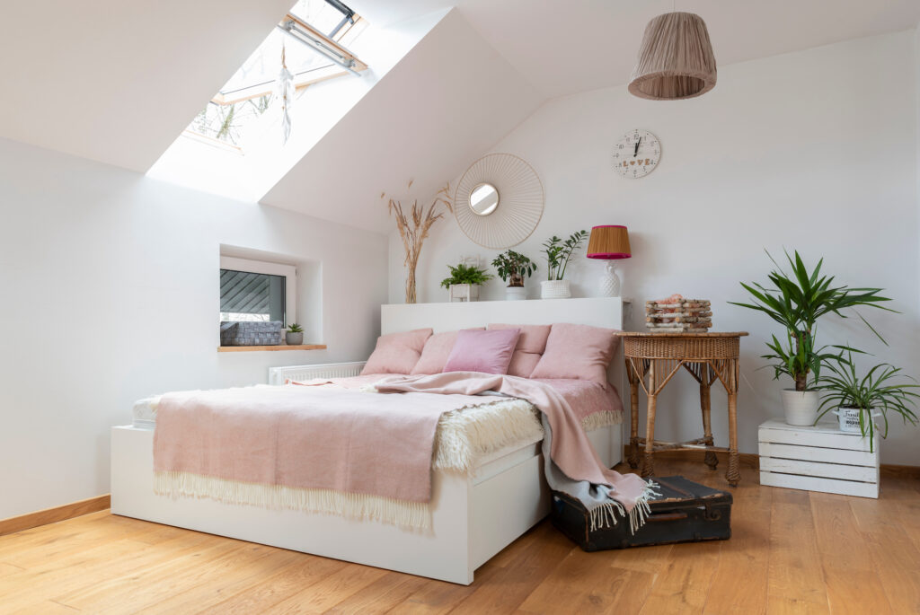 Picture of a loft bedroom with pink pillows and wooden floors