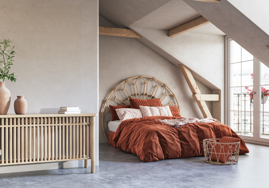 Picture of a loft bedroom with a large bed with rust coloured sheets
