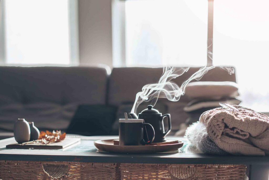 Picture of a cup of tea on a coffee table with a grey sofa in the background